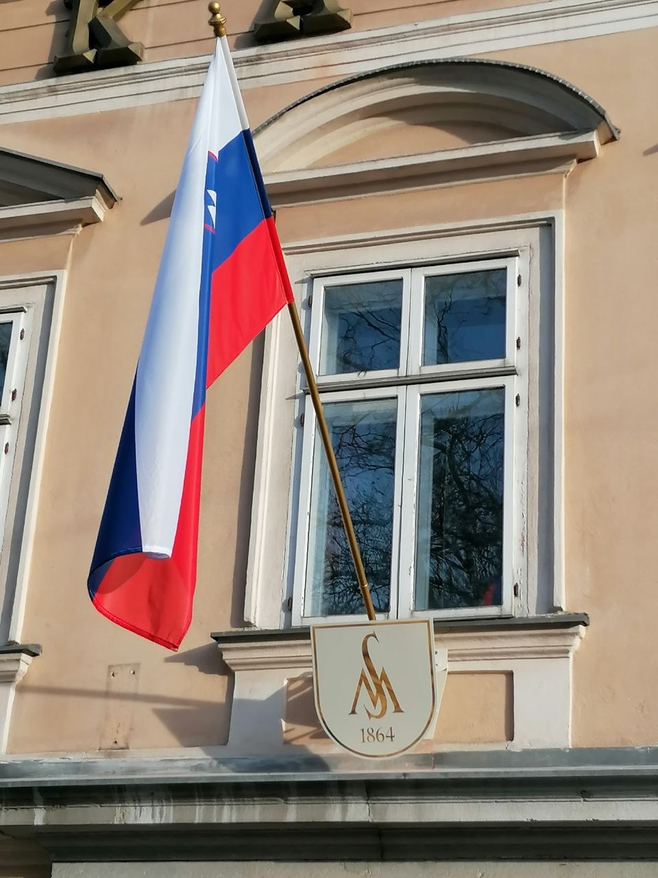 Zgradba Glasbene matice v Ljubljani z zastavo in znakom ustanove