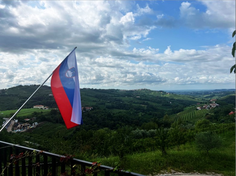 Zastava na balkonu z razgledom na gričevje z vinogradi nad Humom na Primorskem